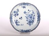 a blue and white plate with a floral design on it