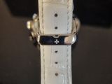 a close up of a watch with a white strap