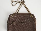 un sac à main marron muni d'une chaîne qui se porte à l'épaule