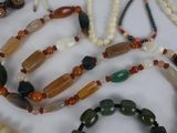 many necklaces and bracelets that are on a table
