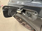 a black car with a gas pump attached to it ' s rear end