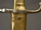 a close up of a gold colored sword with a black background