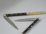 two knives that are laying next to each other on a table