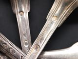 four spoons and a fork on a black surface