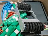 une boîte contenant plusieurs tuyaux verts et une paire de ciseaux