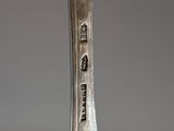 a close up of a silver spoon with a bird on it