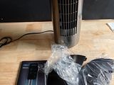 un ventilateur posé sur une table en bois à côté d'un CD