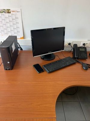 un bureau sur lequel se trouvent un ordinateur, des haut-parleurs et un clavier