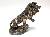 statue of a lion on a rock on a white background