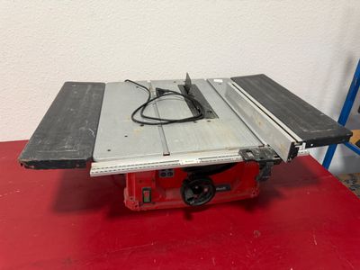 une scie circulaire à table est posée sur une table rouge