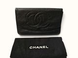 a black chanel wallet with a black case next to it