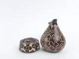 two vases sitting next to each other on a white surface