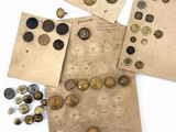 quelques morceaux de vieux papier et de vieilles pièces de monnaie posés sur une surface blanche