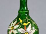 un vase en verre vert orné de fleurs peintes