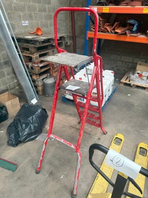 un tabouret rouge au milieu d'une pièce