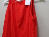 a red dress hanging on a hanger in front of a white wall
