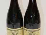 deux bouteilles de vin posées sur une table l'une à côté de l'autre