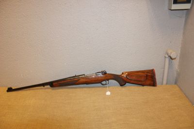 le fusil est posé sur la table près du mur