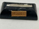 black marble business card holder with a gold label on it