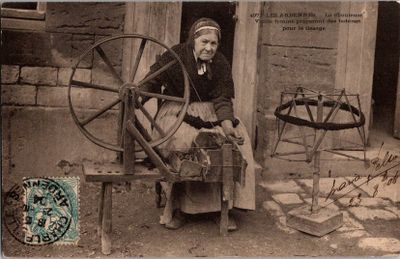 une vieille photo d'une femme en train de filer à l'aide d'un rouet