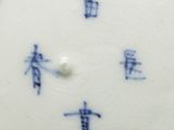 a white plate with blue writing on it and a white plate with blue writing on it