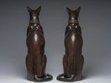 pair of egyptian cat statues on stands on a grey background