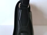 a black purse with a strap on it on a table