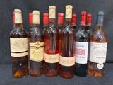 Plusieurs bouteilles de vin sont alignées sur une surface noire