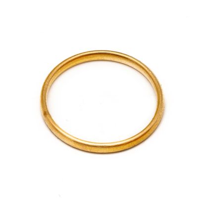 gros plan d'une bague en or sur une surface blanche