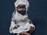 a small doll that is sitting on a black surface
