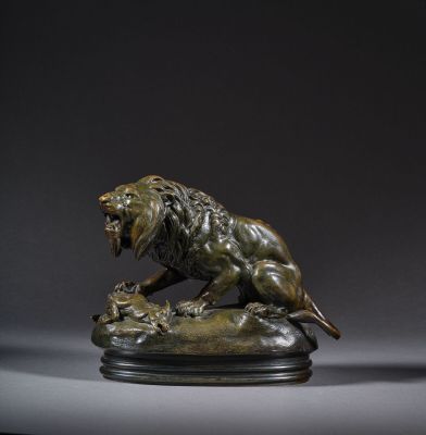 une statue en bronze représentant un lion sur un rocher
