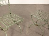 pair of green metal chairs sitting next to each other on a cement floor