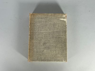 un vieux livre posé sur une table à côté d'un mur blanc