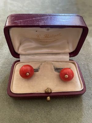 une photo d'une paire de boucles d'oreilles rouges dans un étui violet