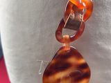 a picture of a necklace that has a brown and white bead on it