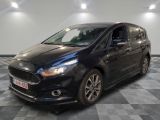 une voiture noire est garée dans une pièce au sol en damier