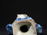 a blue and white vase sitting on a black surface