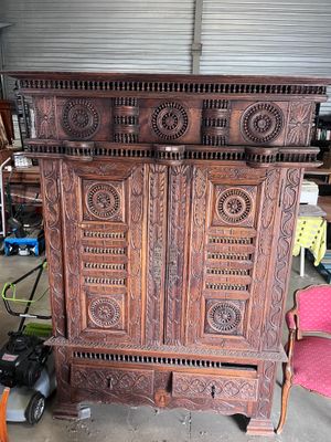 une grande armoire en bois dans un garage, avec un appareil photo