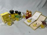 trois flacons de parfum et une boîte de parfum posés sur une surface blanche