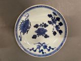 a blue and white plate with flowers and birds on it