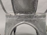 a silver metal chair with a green plant in it
