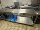 une grande table en acier inoxydable au milieu d'une cuisine