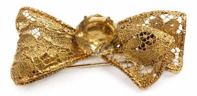 golden bow brooch with a golden crystal center