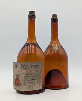 deux bouteilles de vin sont posées l'une à côté de l'autre sur une surface blanche