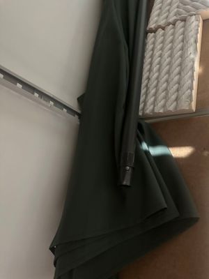 un parapluie noir accroché au mur à côté d'un réfrigérateur blanc