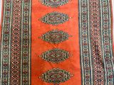an orange and blue rug on a white table