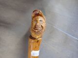 a close up of a wooden stick with a face on it