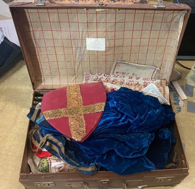 a suit case with a blue cloth and a red cross on it