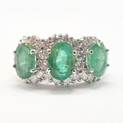 une photo d'une bague à trois pierres, sertie d'émeraudes et de diamants
