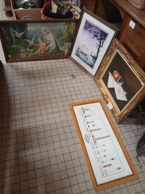 several framed pictures are on the floor in a room